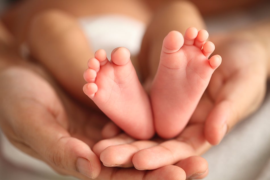 Mother holding newborn's feet.